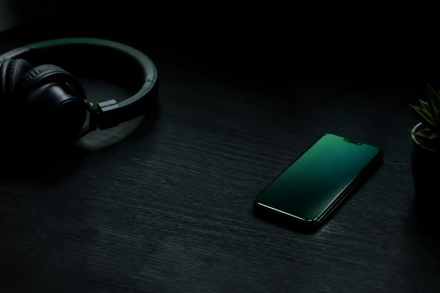 Escritorio con auriculares y un teléfono con luz verde / Desk with a headset and a phone with green light